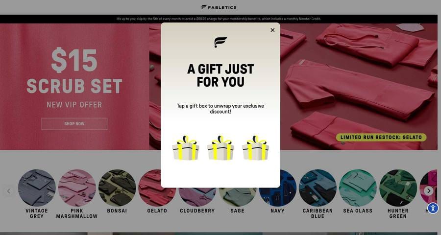 Fabletics scrubs membership page with a gift-box popup covering the hero, Vintage Grey reduced to one swatch among ten