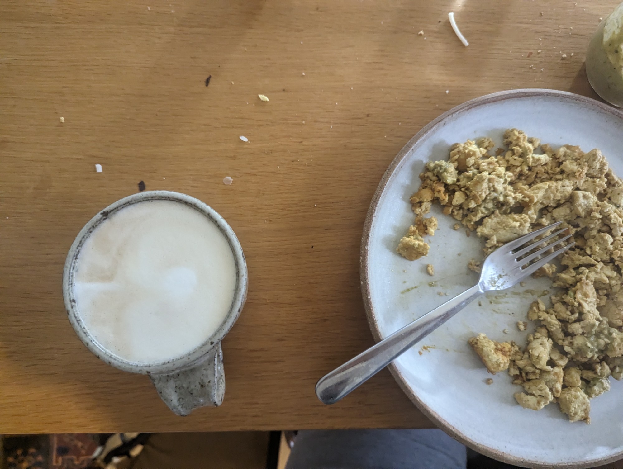 A plate of scrambled tofu next to a latte